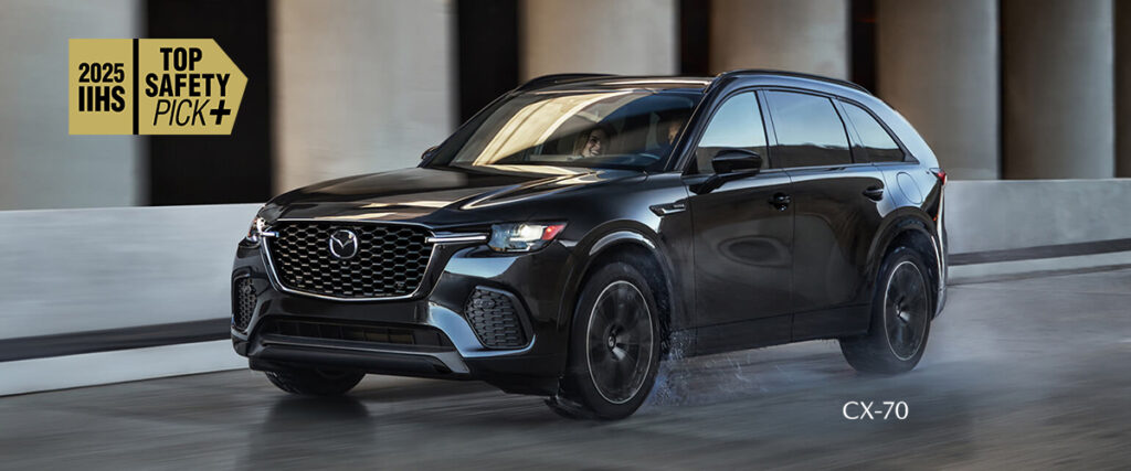 Mazda CX-70 2025 noire en mouvement sous un portique, reconnue IIHS Top Safety Pick+ pour une sécurité optimale